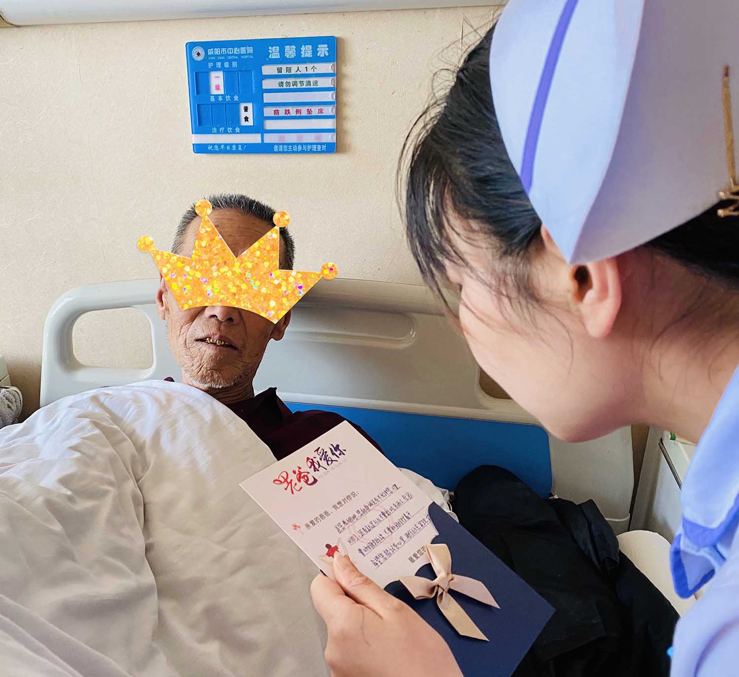 护士为卧床老人朗读子女填写的祝福卡片.jpg